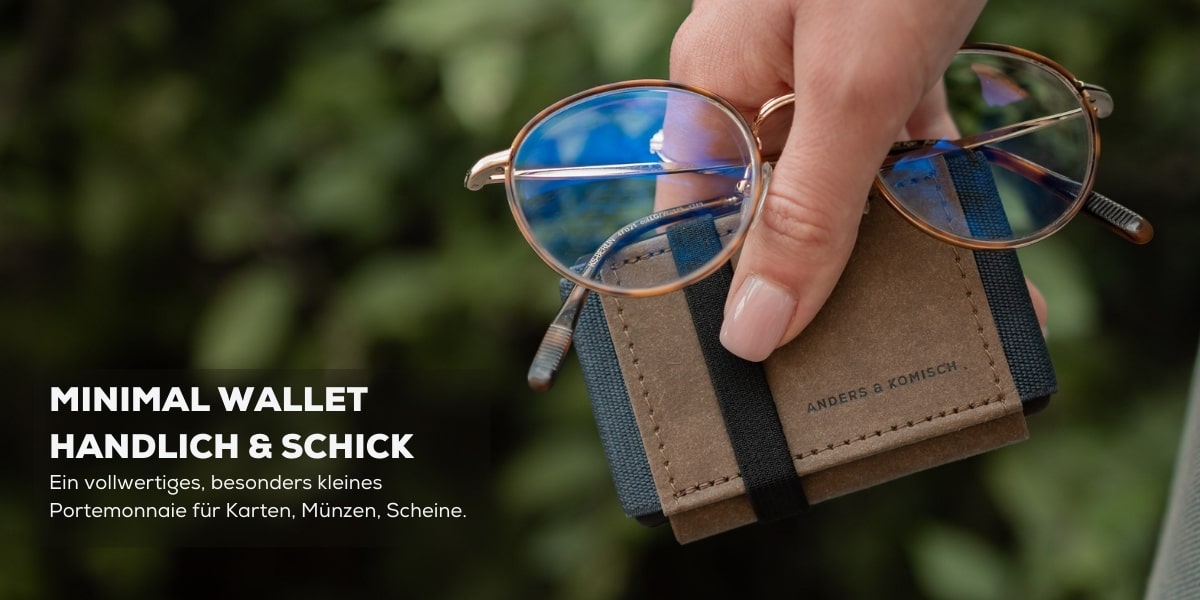 Minimal wallet wird in der Hand mit einer Brille gehalten. Es ist kleiner als die Brille und hat die Farben: Braun/Grau.